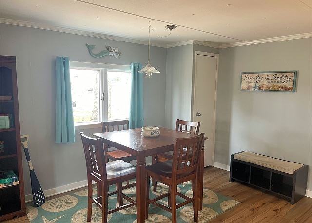 dining space with ornamental molding and hardwood / wood-style floors