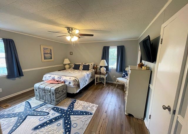 bedroom featuring ornamental molding, dark wood-type flooring, and ceiling fan