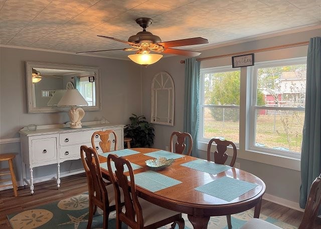 dining space with crown molding, ceiling fan, and dark hardwood / wood-style floors