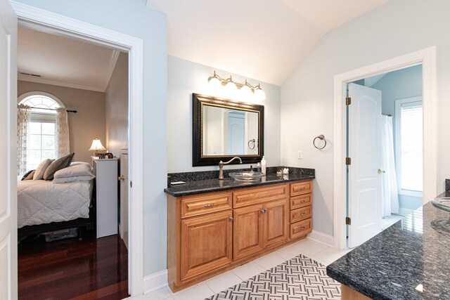 bathroom featuring tile patterned floors, crown molding, vanity, and lofted ceiling