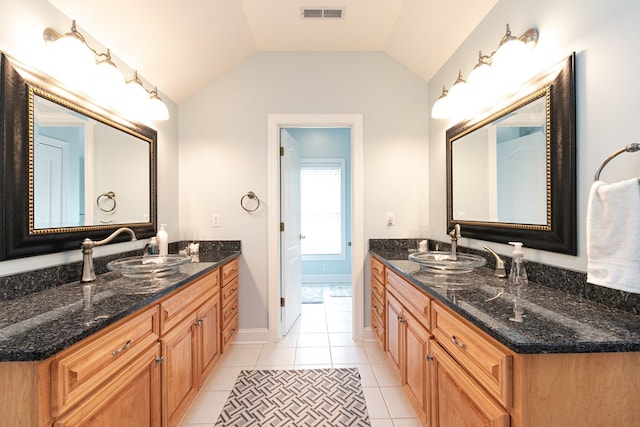 bathroom featuring tile patterned floors, vanity, and vaulted ceiling