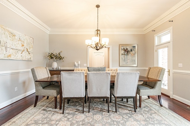 dining space with hardwood / wood-style floors, an inviting chandelier, and ornamental molding