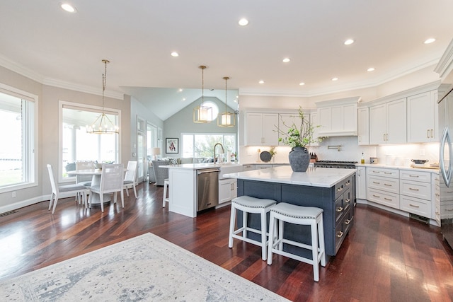 kitchen with white cabinets, a kitchen breakfast bar, kitchen peninsula, and appliances with stainless steel finishes