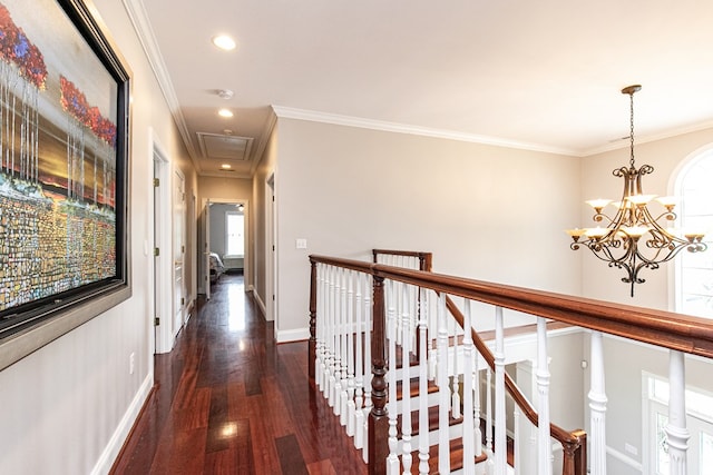 hall featuring dark wood-type flooring, a chandelier, and ornamental molding