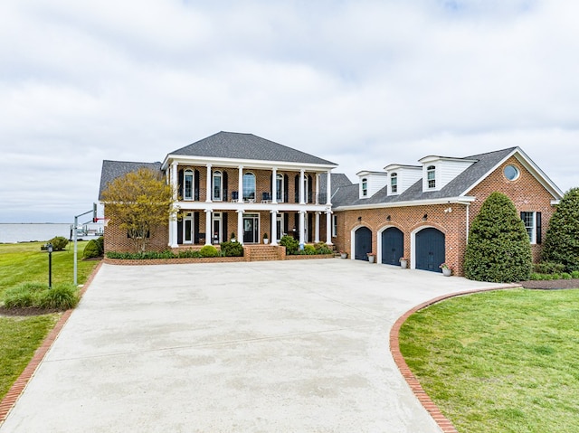 view of front of property with a garage, covered porch, and a front lawn