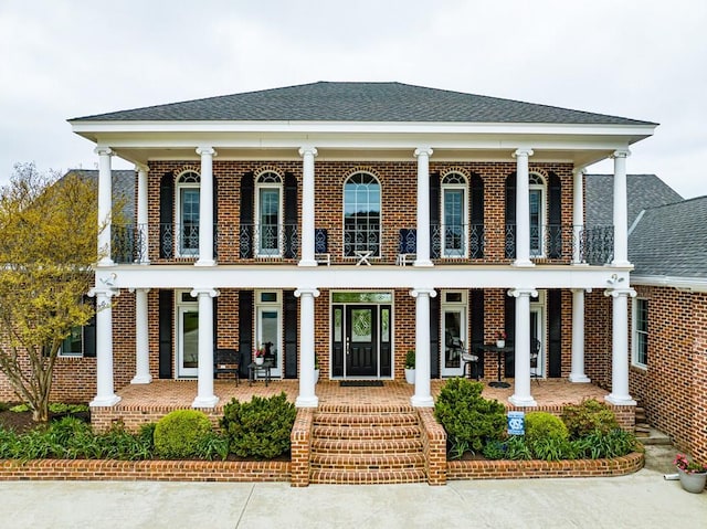 view of front of property featuring covered porch and a balcony