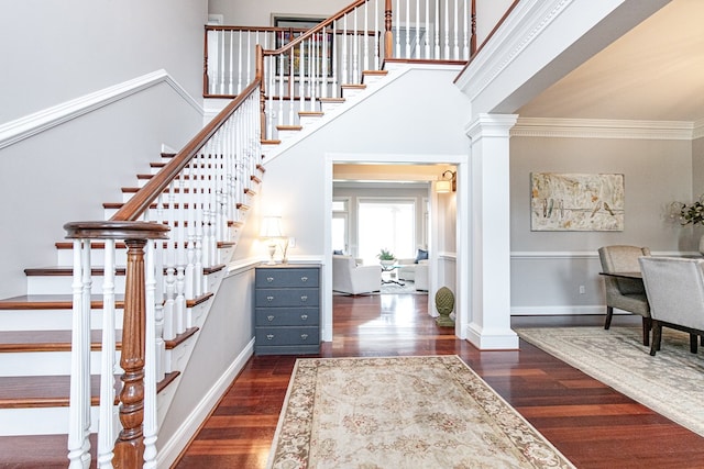 staircase with wood-type flooring and crown molding