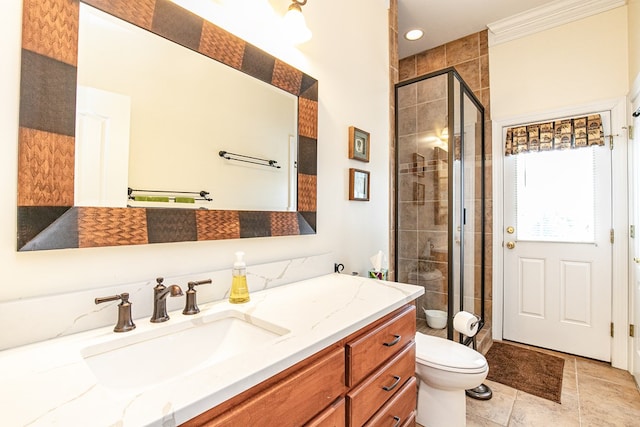 bathroom with vanity, toilet, a shower with shower door, and crown molding