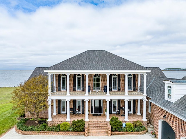 greek revival house with a balcony and a water view