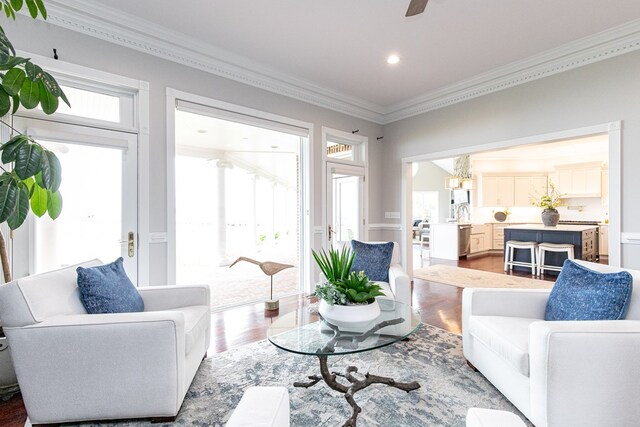 living room featuring crown molding, hardwood / wood-style floors, a chandelier, and plenty of natural light