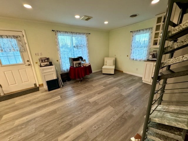 entryway with hardwood / wood-style flooring and crown molding