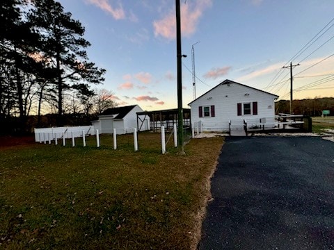 property exterior at dusk featuring a yard