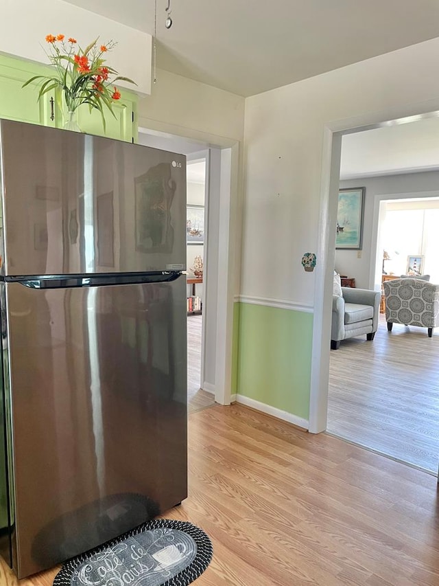 7669 E Side Rd, Chincoteague, VA 23336 - kitchen with freestanding refrigerator, light wood-type flooring, and baseboards