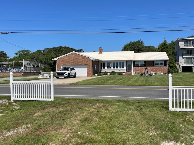 7669 E Side Rd, Chincoteague, VA 23336 - view of front of house with brick siding, a chimney, a garage, and concrete driveway