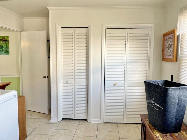 7669 E Side Rd, Chincoteague, VA 23336 - bedroom featuring ornamental molding, light tile patterned flooring, and two closets