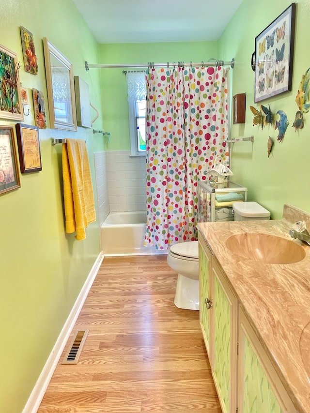 7669 E Side Rd, Chincoteague, VA 23336 - full bath featuring wood finished floors, toilet, shower / tub combo with curtain, vanity, and baseboards