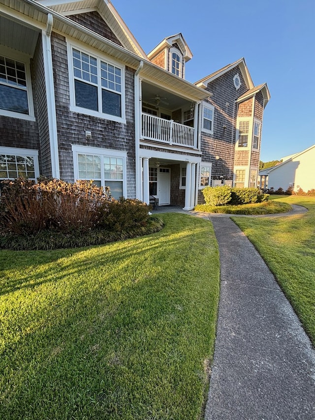 view of front of house with a balcony and a front lawn