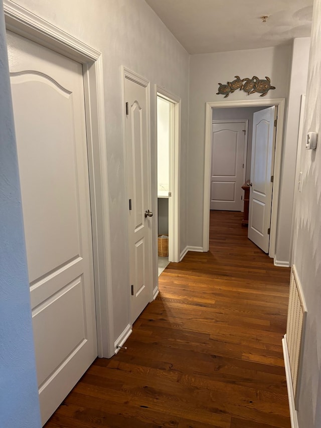 corridor with dark hardwood / wood-style flooring