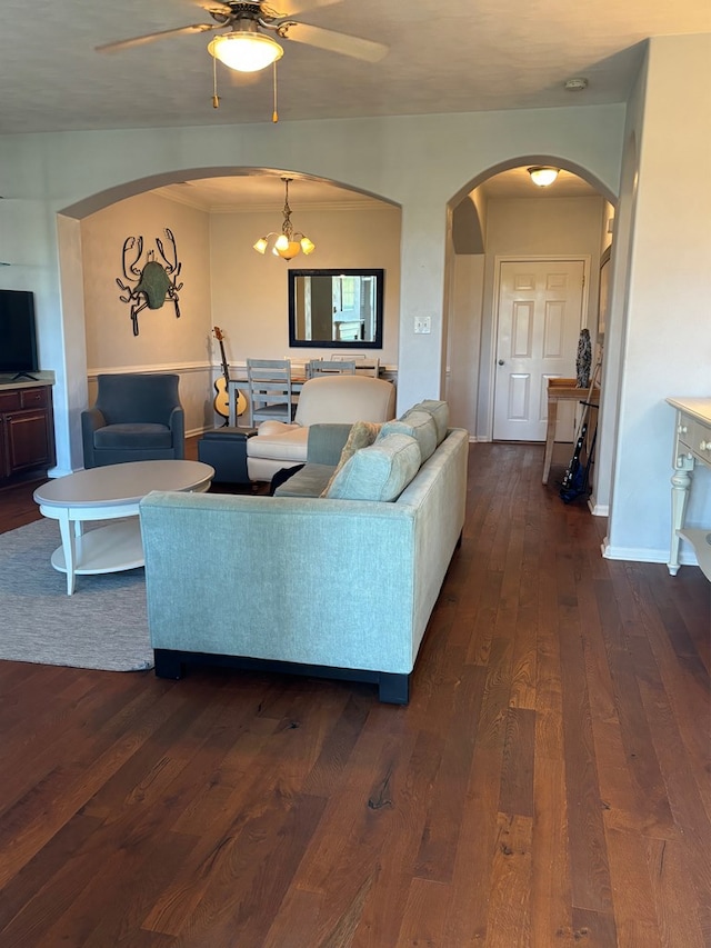 living room with dark hardwood / wood-style flooring and ceiling fan with notable chandelier