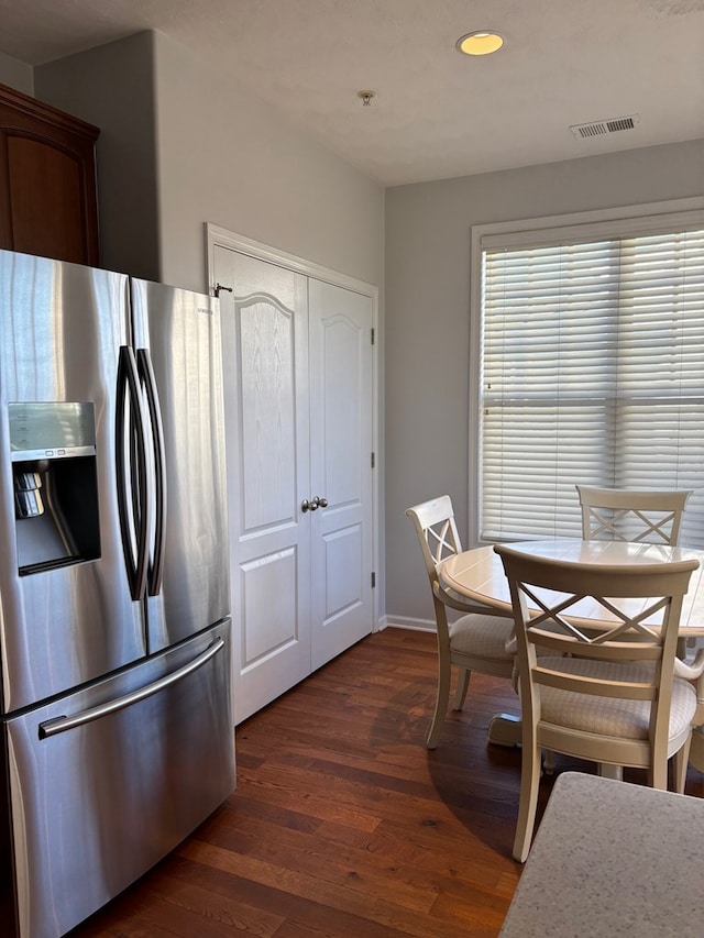 kitchen featuring stainless steel fridge and dark hardwood / wood-style flooring