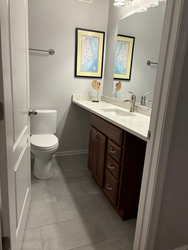 bathroom featuring vanity, tile patterned floors, and toilet