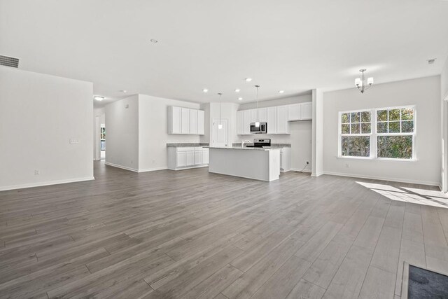 LOT476 Driftwood Dr, Greenbackville, VA 23356 - unfurnished living room featuring dark wood-style flooring, recessed lighting, baseboards, and a chandelier