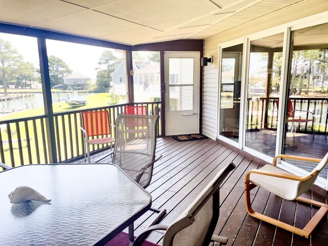 sunroom / solarium featuring a water view