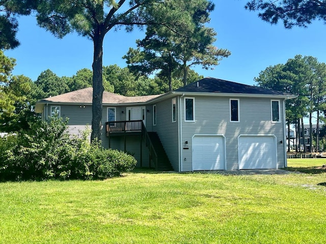 back of property with a garage and a lawn