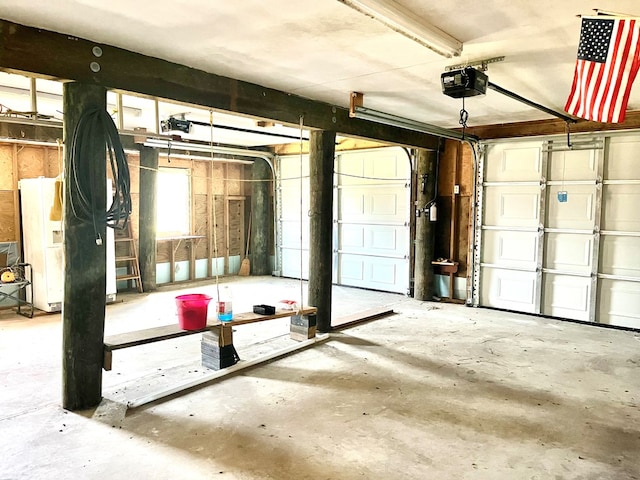 garage featuring white refrigerator and a garage door opener