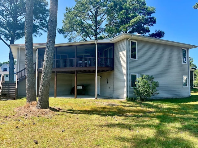 back of house featuring a sunroom, a lawn, and a patio area