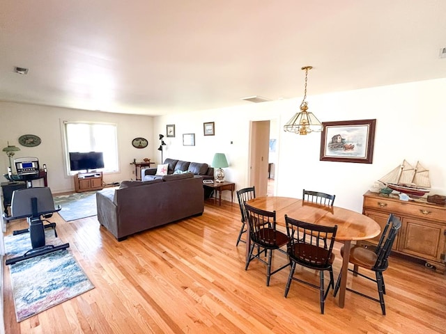 dining area with a notable chandelier and light wood-type flooring