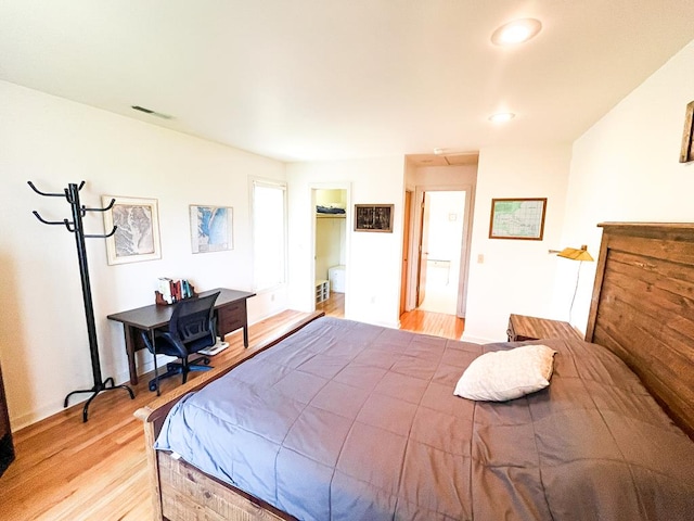 bedroom featuring a spacious closet, light hardwood / wood-style floors, and a closet