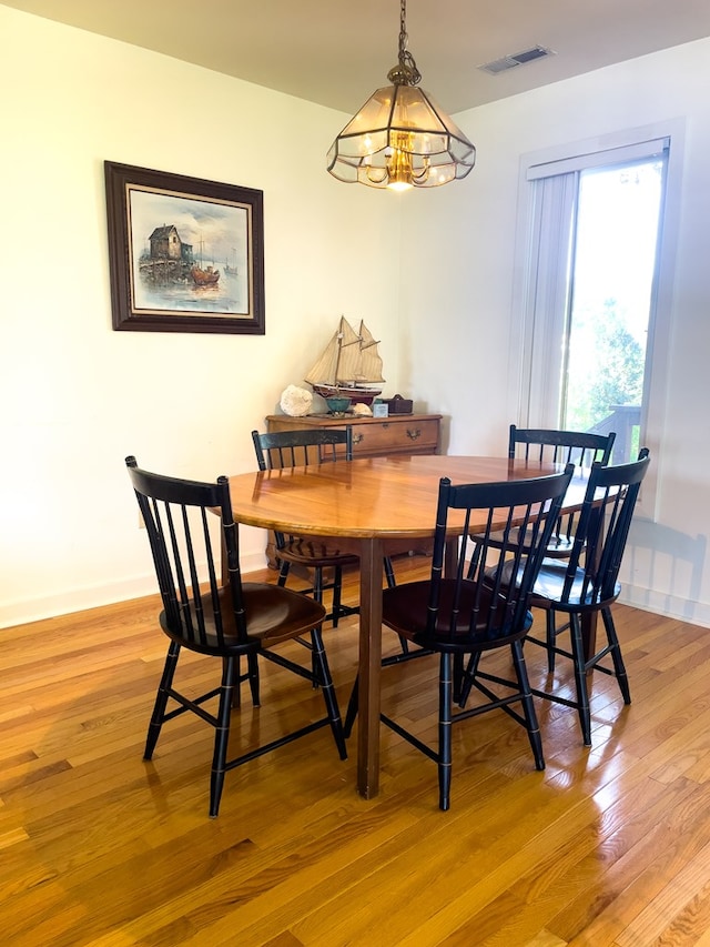 dining space featuring hardwood / wood-style floors and a notable chandelier