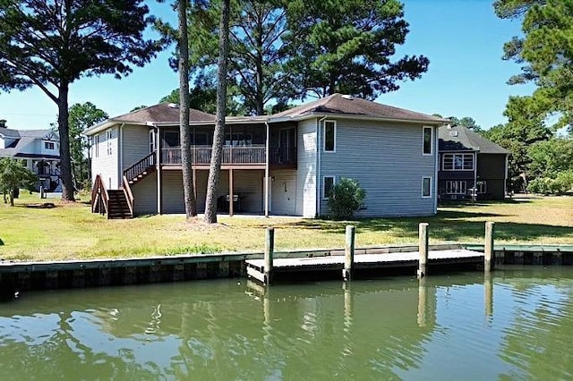 rear view of house with a yard and a water view