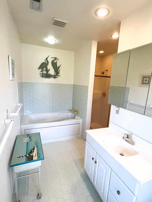 bathroom featuring tile patterned flooring, a bath, and vanity