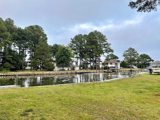 view of property's community featuring a lawn and a water view