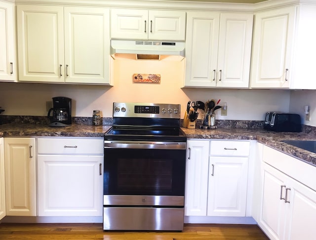 kitchen with range hood, white cabinetry, stainless steel range with electric cooktop, and hardwood / wood-style flooring