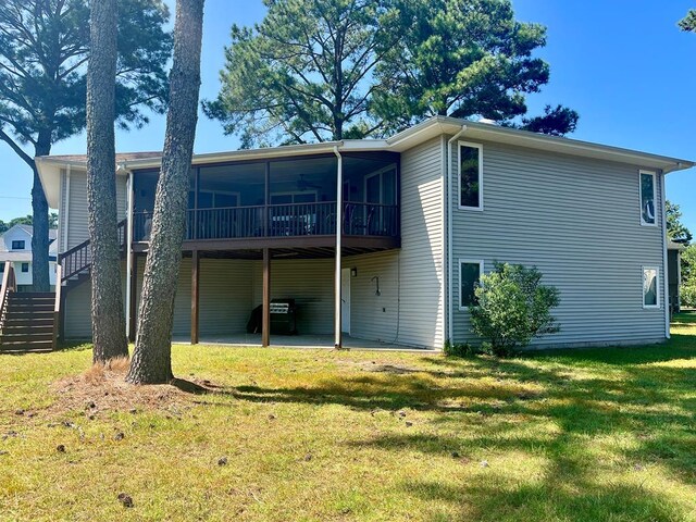 back of house featuring a sunroom, a yard, and a patio area