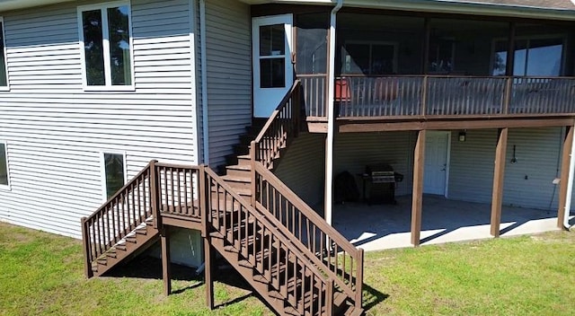 rear view of property with a yard, a deck, and a patio area