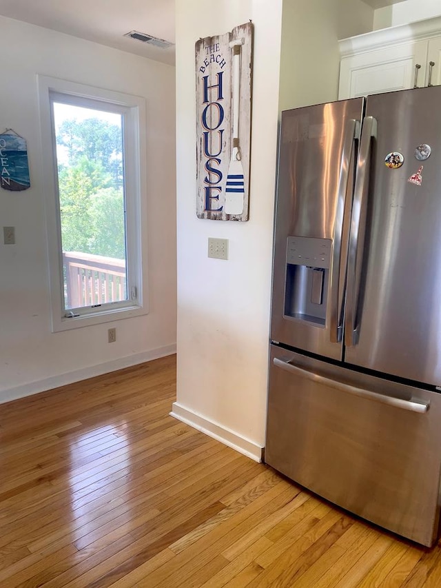 kitchen featuring white cabinetry, light hardwood / wood-style flooring, and stainless steel fridge with ice dispenser