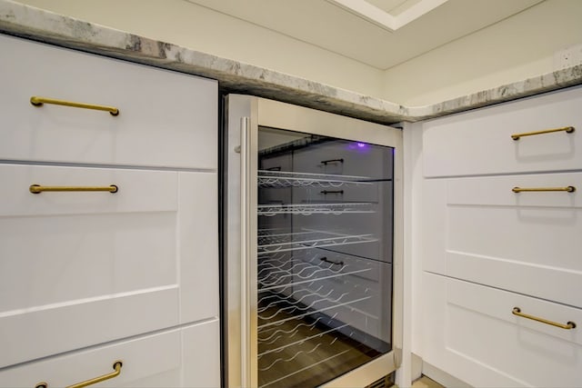 interior details with wine cooler and white cabinetry