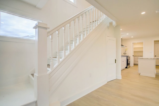 staircase featuring wood finished floors and recessed lighting