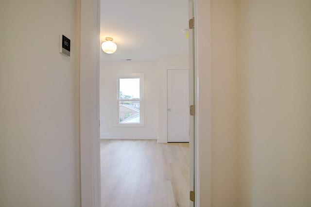 hall featuring baseboards and light wood finished floors