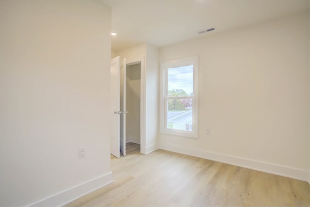 unfurnished room with light wood-style flooring, baseboards, visible vents, and recessed lighting