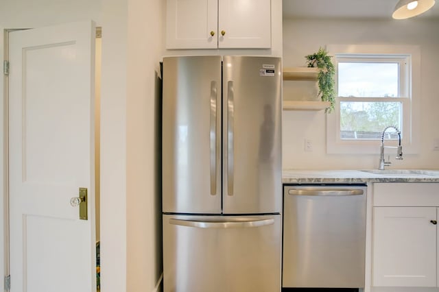 kitchen with white cabinets, open shelves, stainless steel appliances, and a sink