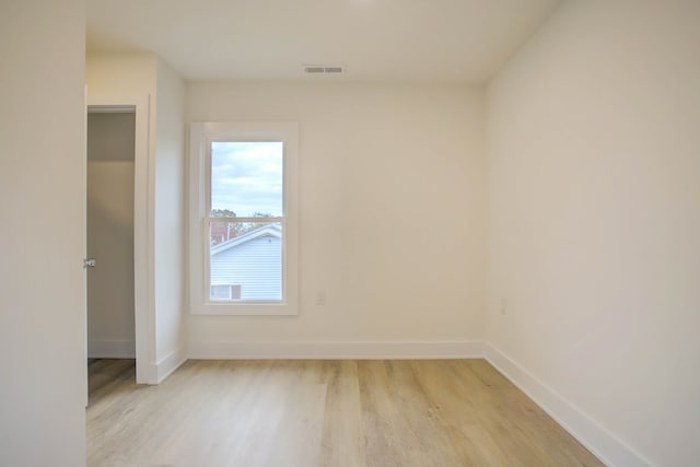 unfurnished room with light wood-style floors, baseboards, and visible vents