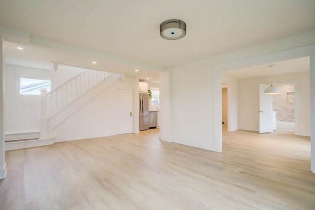 unfurnished living room with baseboards, stairs, light wood-style floors, and recessed lighting