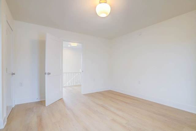 spare room with light wood finished floors and baseboards