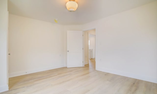 empty room featuring light wood-style flooring and baseboards