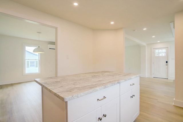 kitchen with white cabinetry, recessed lighting, light wood-style floors, and a wall unit AC